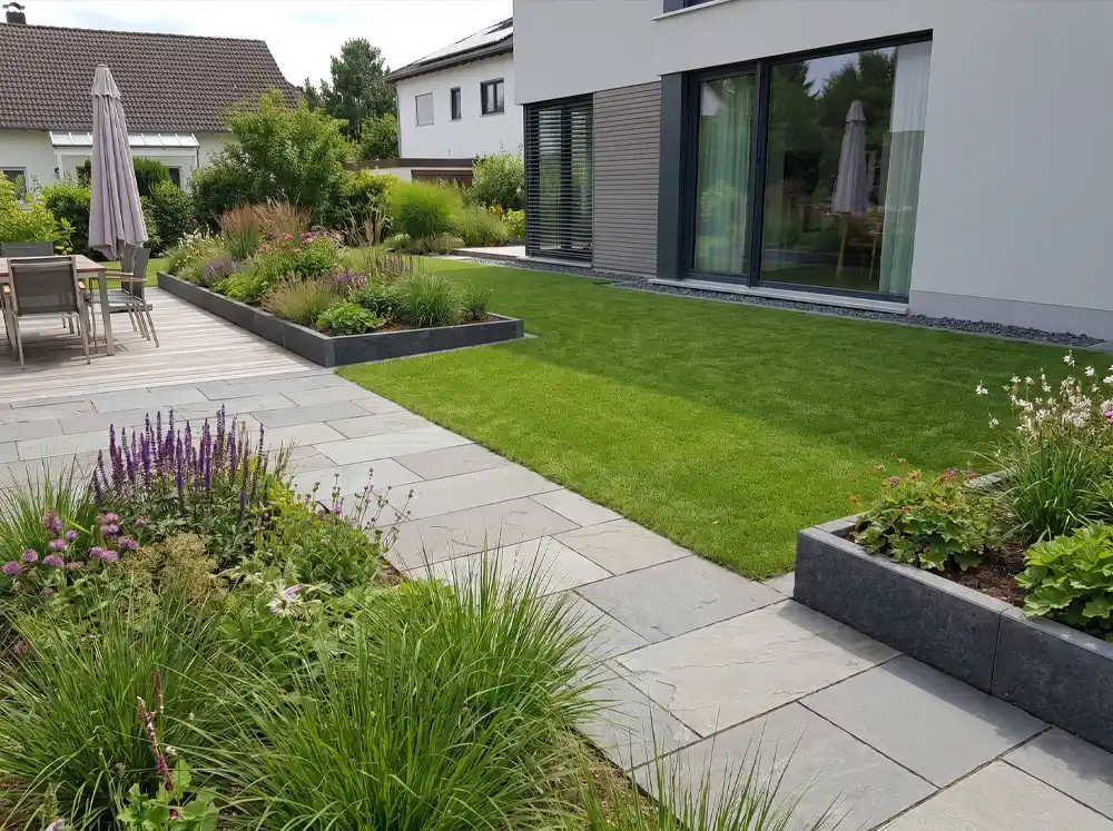 Neue Rasenfläche ist sauber mit Gartenweg, Beeten und Terrasse verbunden